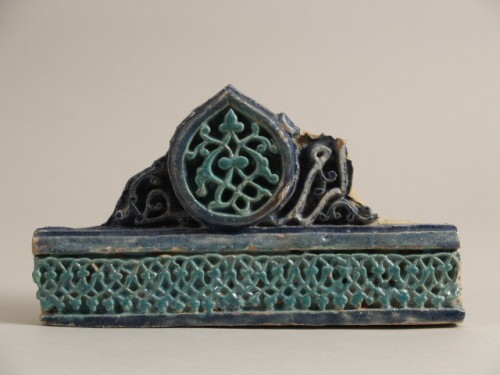 Bouwkeramiek, fragment, met decor van arabesken en fragment van tekst