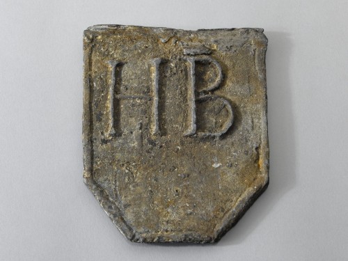 Trotseerloodje in schildvorm met de initialen H.B.