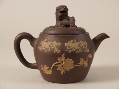Theepot met decor van bloemen en knop in de vorm van een leeuw