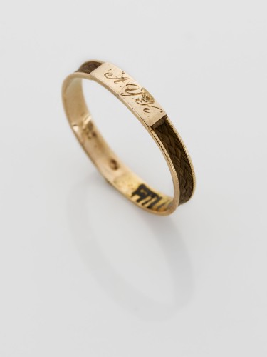 Dunne gouden ring van gevlochten haarwerk voorzien en smal plaatje waarop A.Y.K.