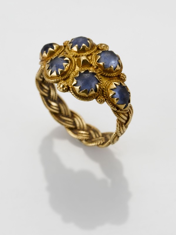 Gevlochten gouden ring met zes blauwe steentjes bezet