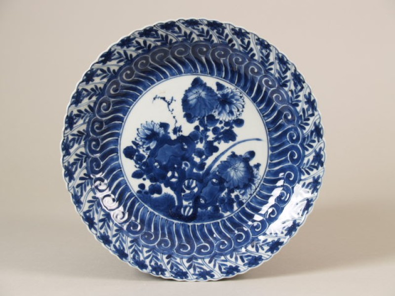 Schotel met een voorstelling van een rotspartij en een chrysant