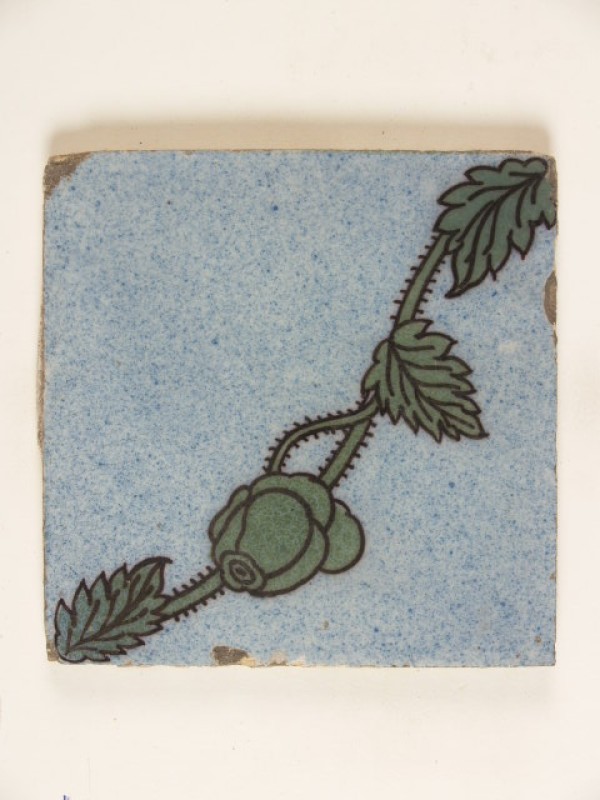 Tegel met een groen floraal en diagonaal ornamentdecor op een blauw gesprenkeld fond