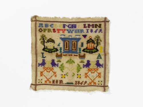 Merkletterlap met alfabet, motieven, huisjes, kast, vogels, initialen LA, tweemaal IIR 1869