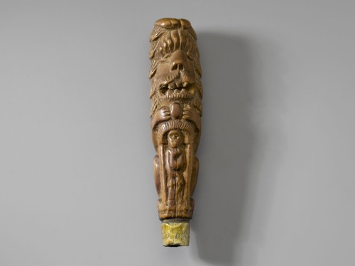 Besneden houten mesheft in de vorm van een zittende leeuw, onderaan een vrouw met anker (Hoop)