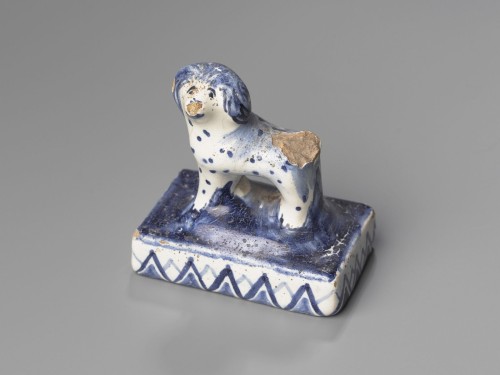 Klein staand hondje van aardewerk op voetstuk