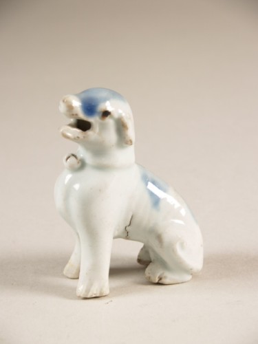 Hond, zittend, met halsband waaraan bel