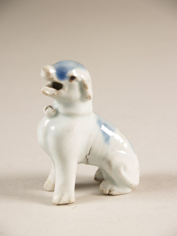 Hond, zittend, met halsband waaraan bel
