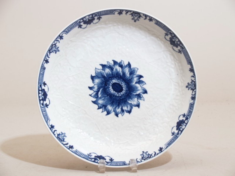 Bord met blauwwit bloemdecor en witte bloem- en bladranken in reliëf