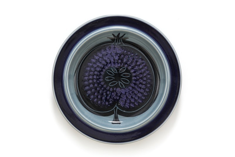 Bord met grijs-blauw glazuur met kobaltblauwe rand en decor van een gehalveerde granaatappel